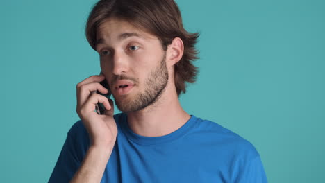 caucasian man in front of camera on blue background.