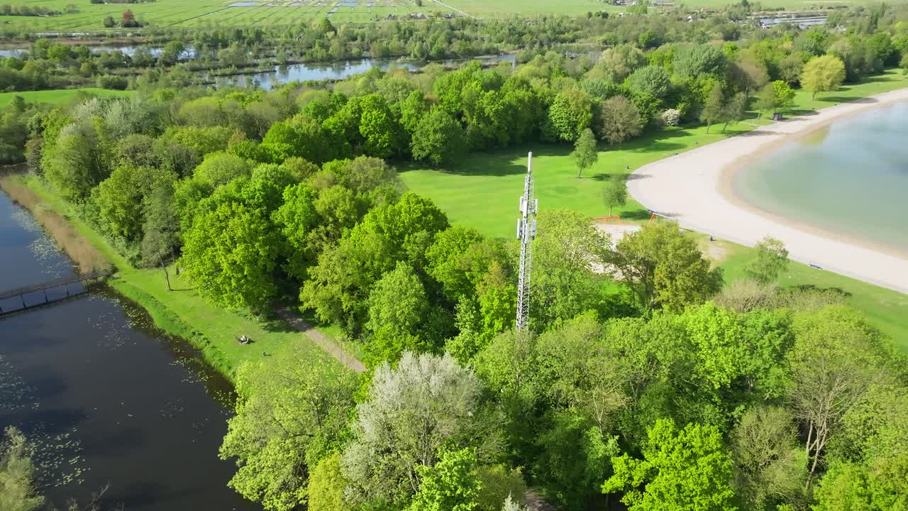 telecommunication mast tower real time aerial retreat, revealing public park, infrastructure for mobile 5g network