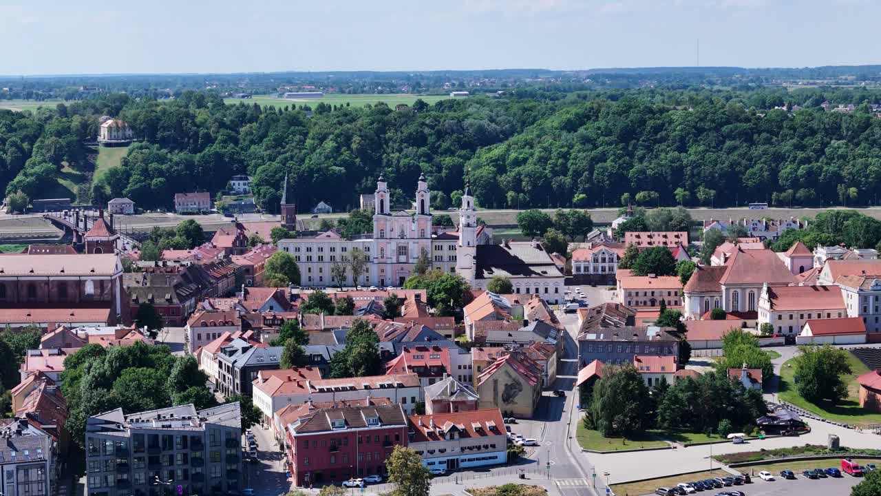 Beautiful church and town hall towers over red rooftops of Kaunas oldtown, aerial view