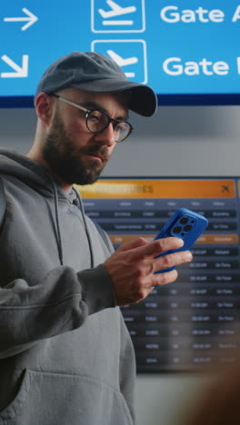 man checking flight schedule at airport