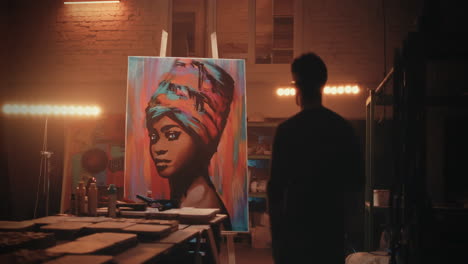 artist viewing colorful african woman portrait in studio