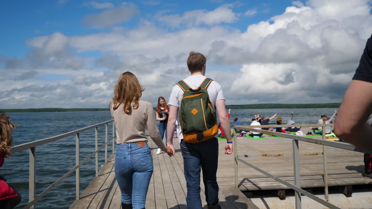 pareja caminando en un muelle junto al lago