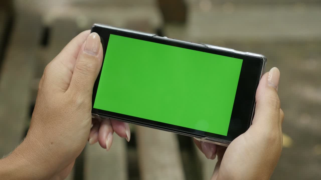 초록색 스크린 스마트폰을 들고 있는 금발 여자