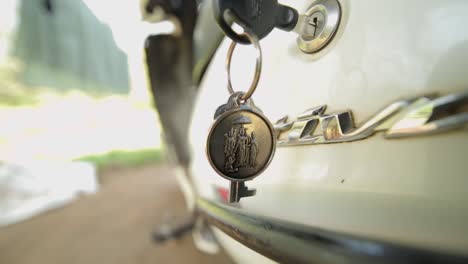 llaves de coche en una cerradura, llavero con símbolos religiosos