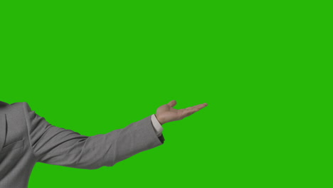 cerca del brazo de un hombre de negocios con traje que presenta o muestra algo contra la pantalla verde
