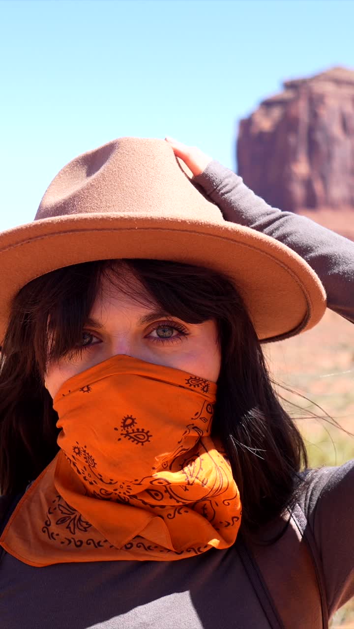 Donna avventurosa con cappello e bandana in un paesaggio desertico