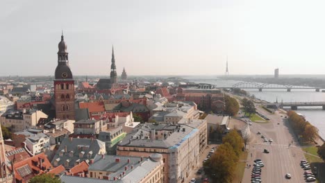 Drone-Aéreo-Del-Paisaje-Urbano-De-Riga-Por-El-Río-Daugava-Con-La-Catedral-De-Santa-María,-Día