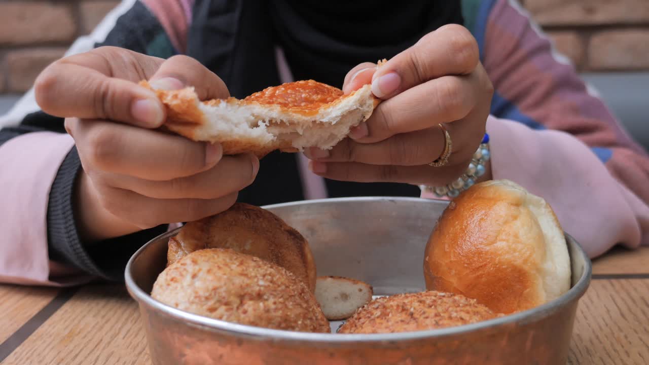 mujer comiendo rollos de pan