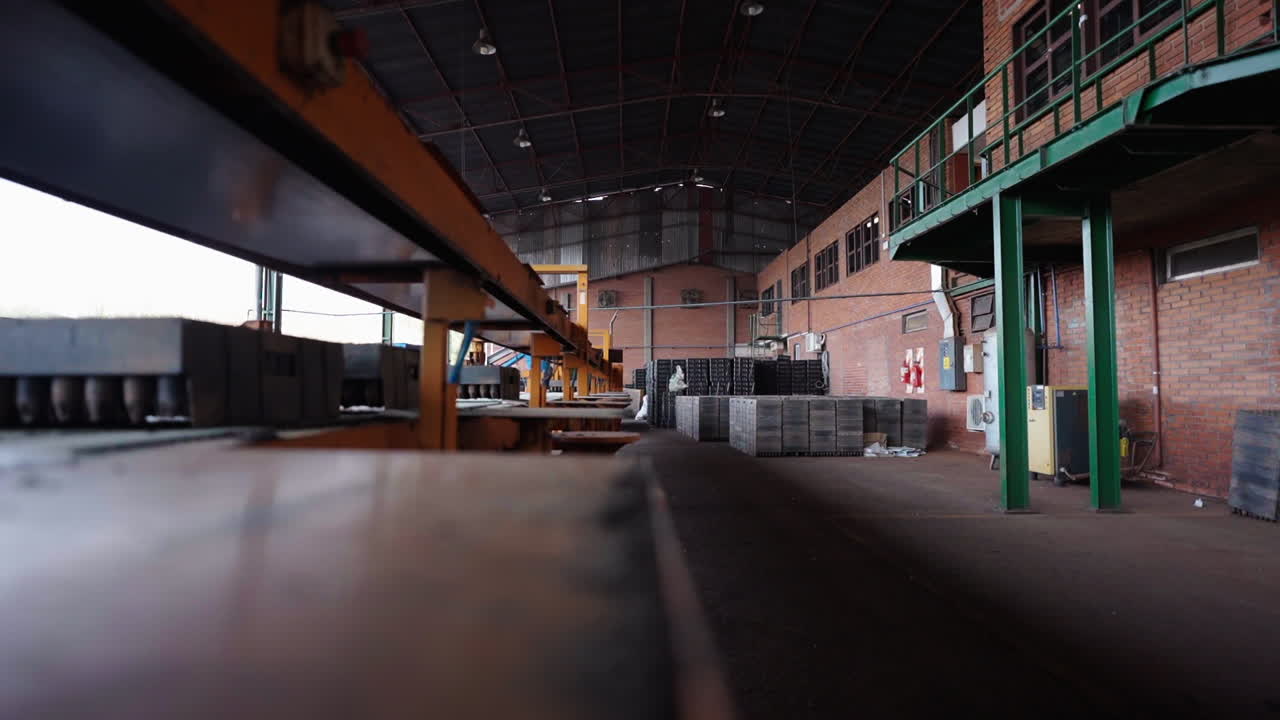 Interior of an industrial factory space with large machinery and a production line setup.