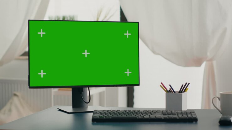 Potente computer con mock-up di schermo verde chroma key posizionato su scrivania