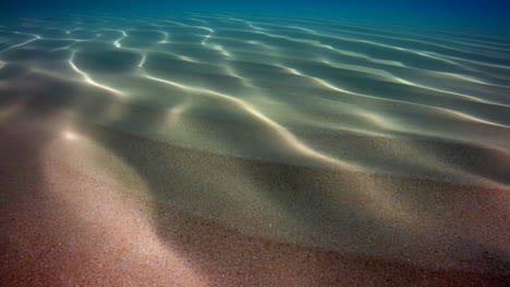 sunlight patterns on sandy underwater floor