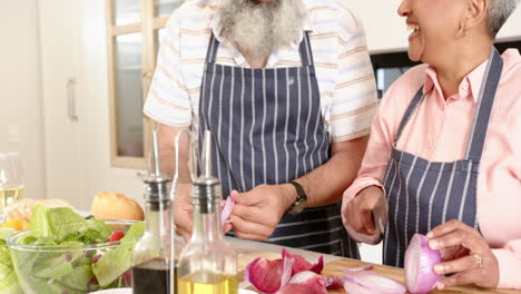 senior couple chopping vegetables and preparing meal together in kitchen