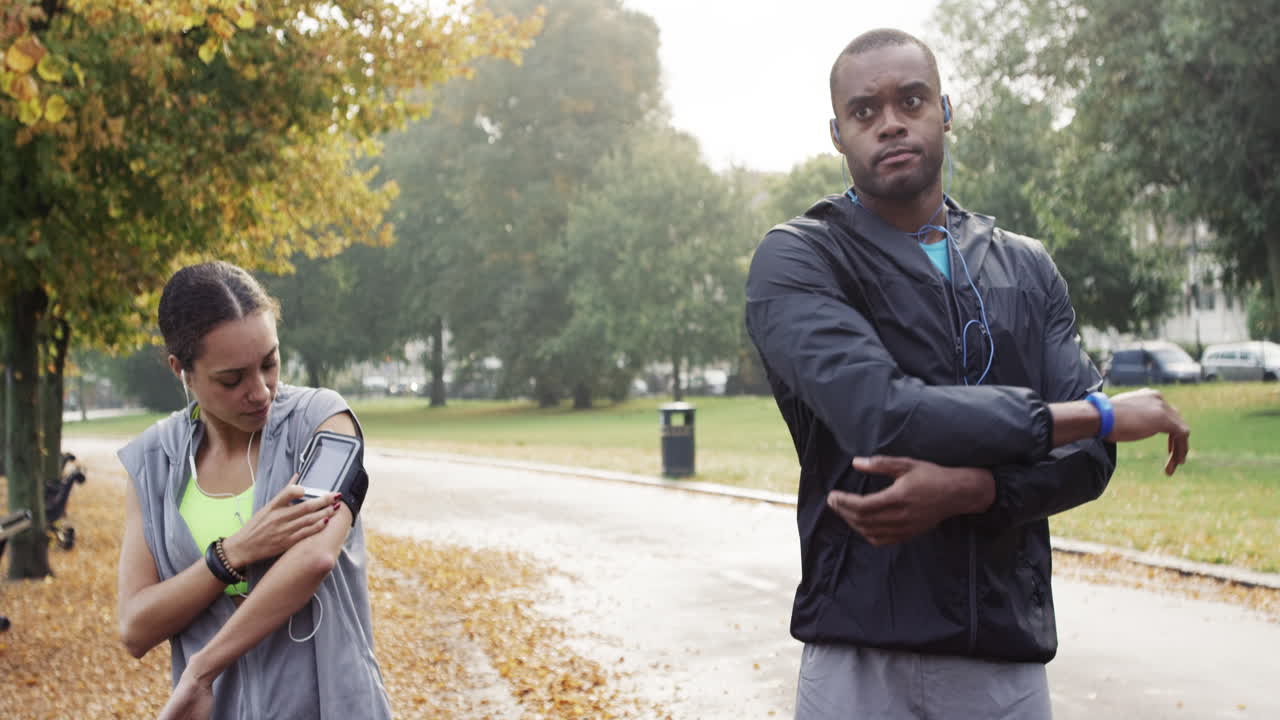 웨어러블 기술과 연결된 장치를 착용한 공원에서 달리는 운동 부부