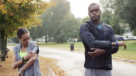 athletic couple running in park wearing wearable technology connected devices