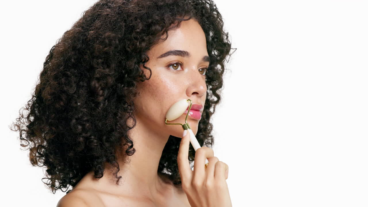 Woman using jade roller for facial massage