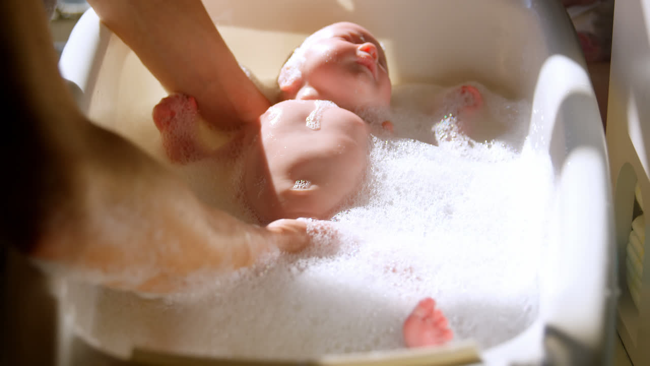 Madre bañando a su bebé en el baño 4K