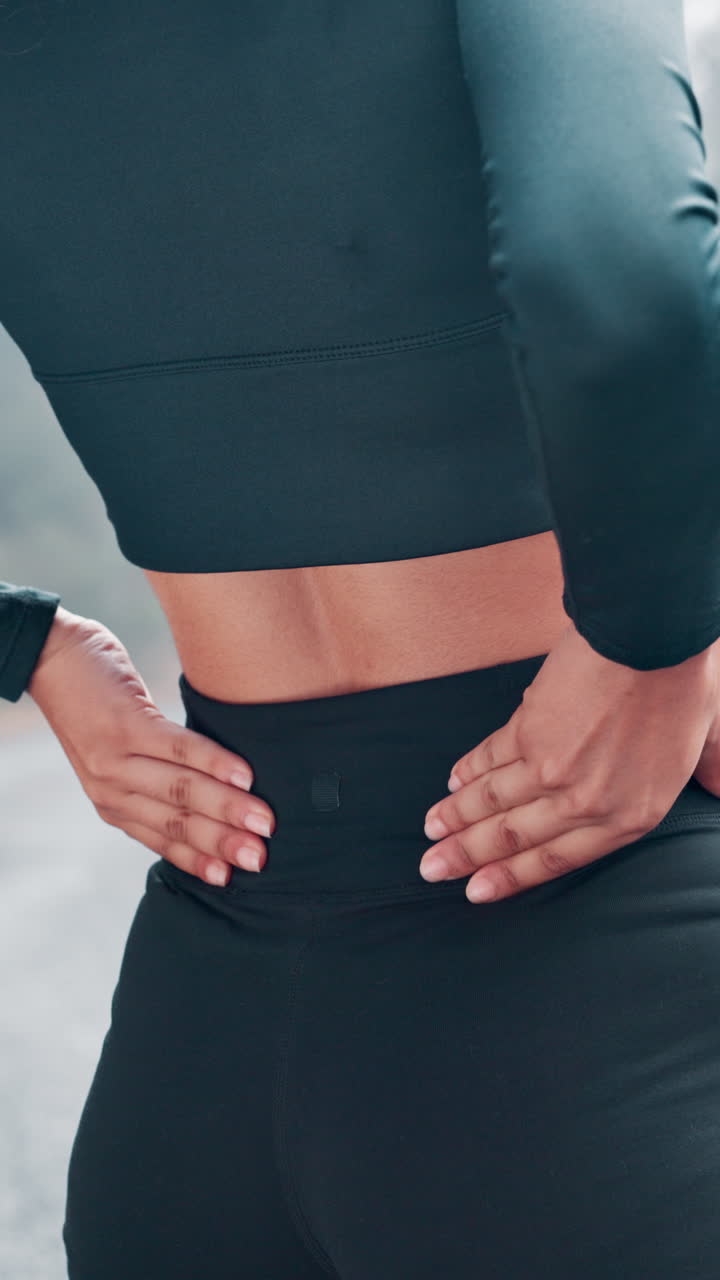 Woman in Athletic Wear Rubbing Her Aching Lower Back