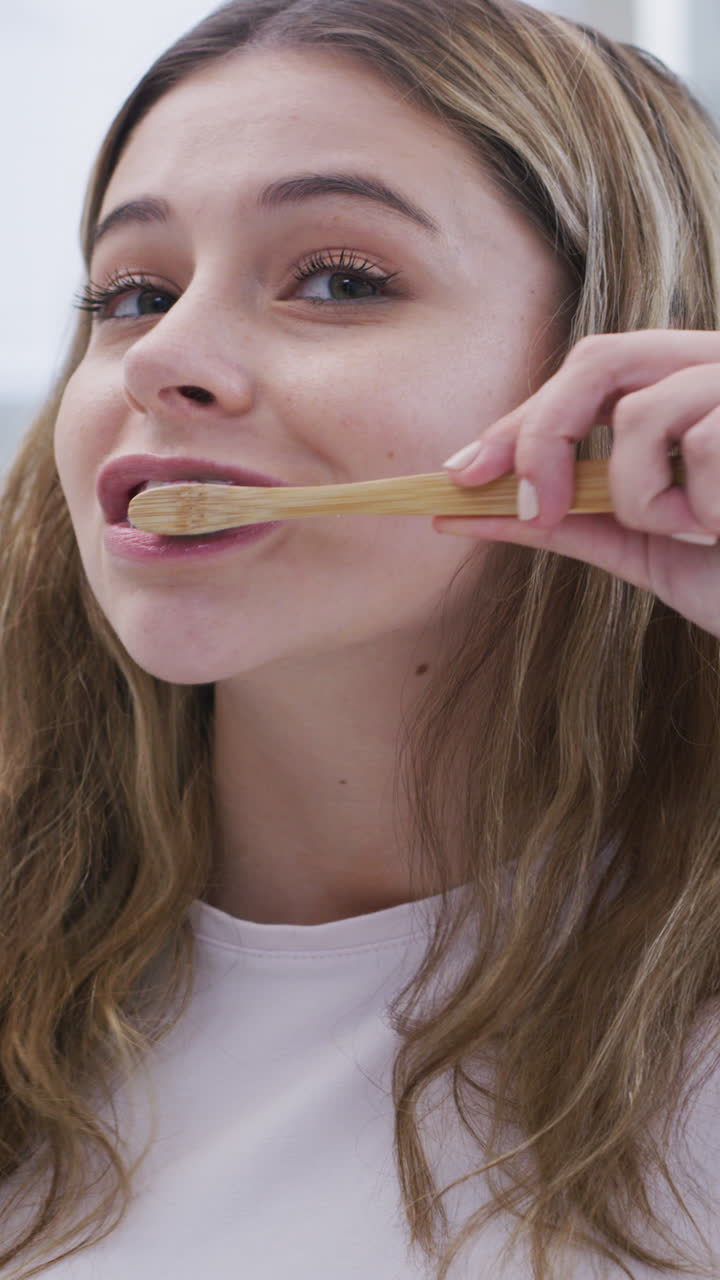Young Woman Brushing Her Teeth with a Bamboo Toothbrush