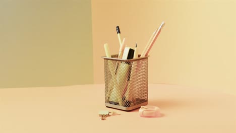 close up de papelería escolar en taza con espacio de copia en fondo amarillo, en cámara lenta
