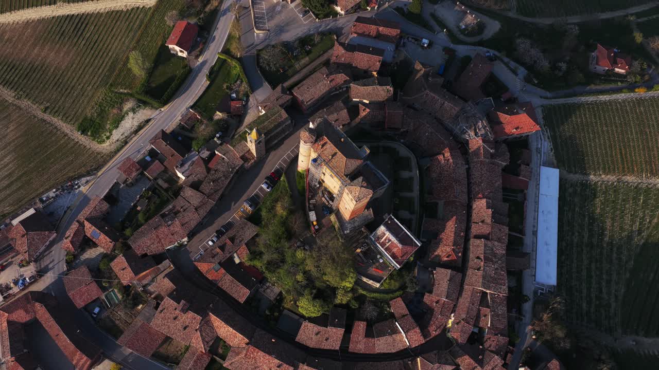 Top-down 360 aerial shot of Serralunga d'Alba’s circular medieval village and castle, surrounded by vineyards, highlighting its unique radial architecture in the heart of Italy’s Langhe region