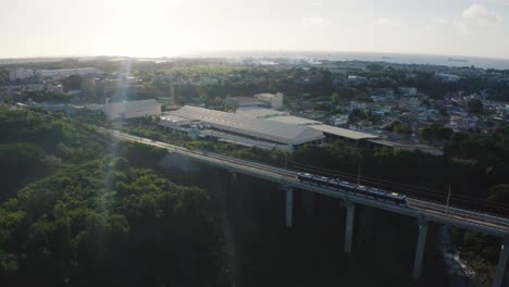 Vista-Aérea-Que-Muestra-La-Conducción-Moderna-Del-Metro-En-El-Puente-Durante-La-Puesta-De-Sol-En-Mauricio,-áfrica