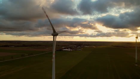 Turbinas-Eólicas-Generadoras-De-Energía-Girando-En-Una-Vista-Escénica-De-La-Puesta-De-Sol---Toma-Aérea