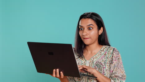 mujer componiendo correo electrónico, escribiendo cuidadosamente en el teclado de la computadora portátil