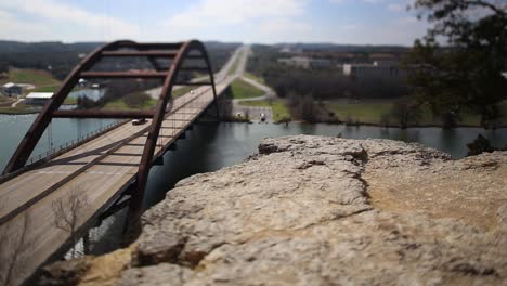 austin pennybacker bridge tilt-shifted time-lapse, focus isolates section of ledge and front part of the bridge. truck is parked on boat ramp getting ready to put it into the water.