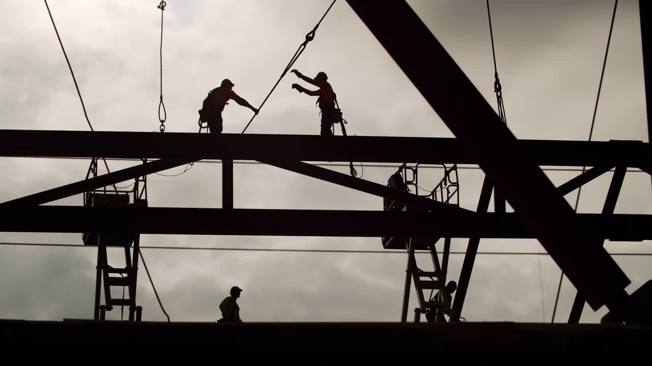Construction Workers Silhouetted Against the Sky