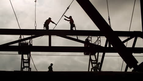 construction workers silhouetted against the sky