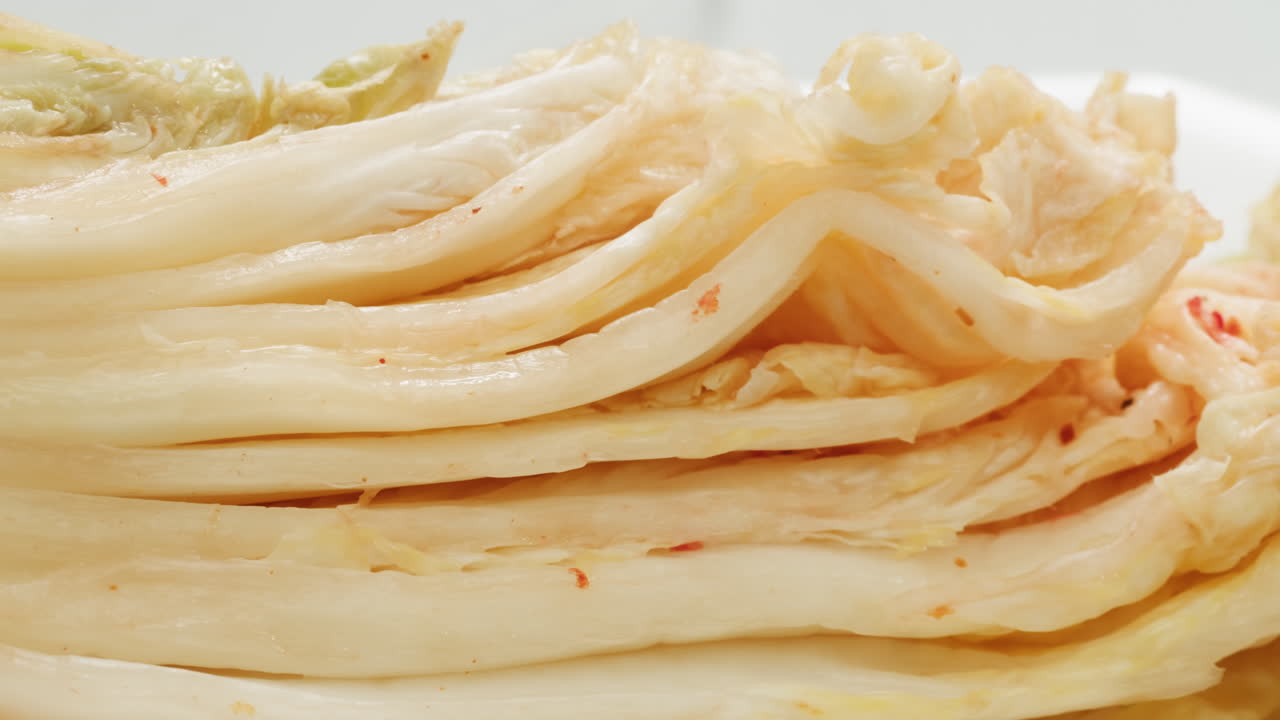 유리 항아리에 채소를 보존하는 캔에서 발효 된 매운 고추 김치의 질의 클로즈업. 향신료와 함께 발효 보존 된 김치 고추 매크로. 아시아 요리. 고품질 4k 영상