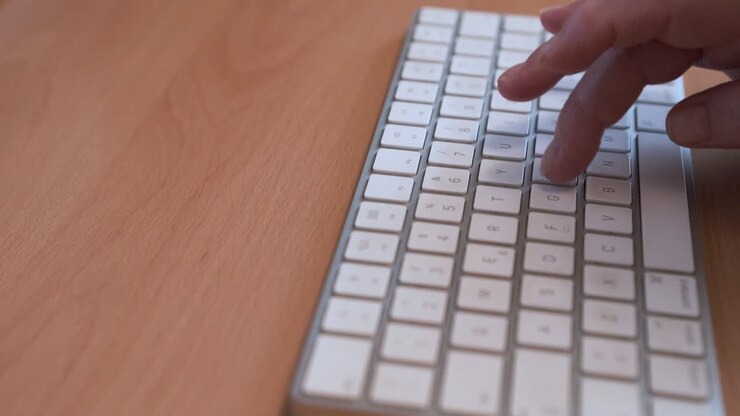 Elderly Human Hand Finger Typing A White Keyboard In Wooden Office Desk