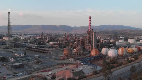 massive petrol industry complex in the surroundings of athens in greece, during sunset, aerial drone footage