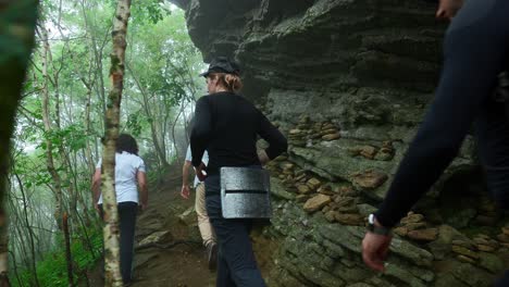 hikers on a mountain trail in foggy forest