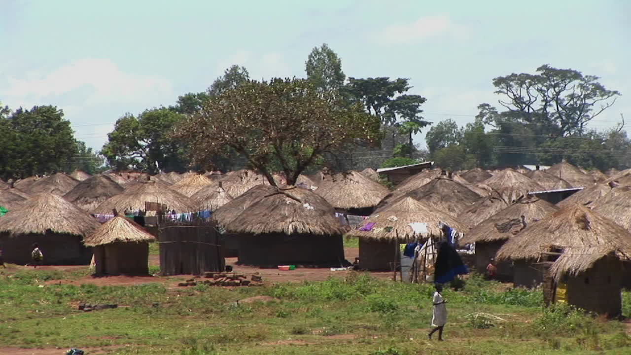 우간다 아프리카의 작은 마을이나 난민 캠프로 걸어가는 어린 소녀의 다음 사진