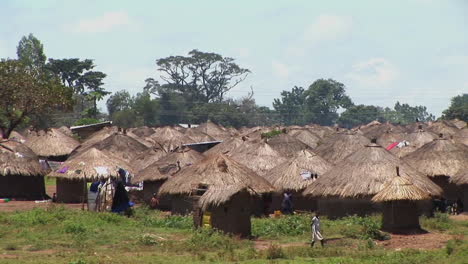 followingshot of a young girl walking to a small village or refugee camp in uganda africa