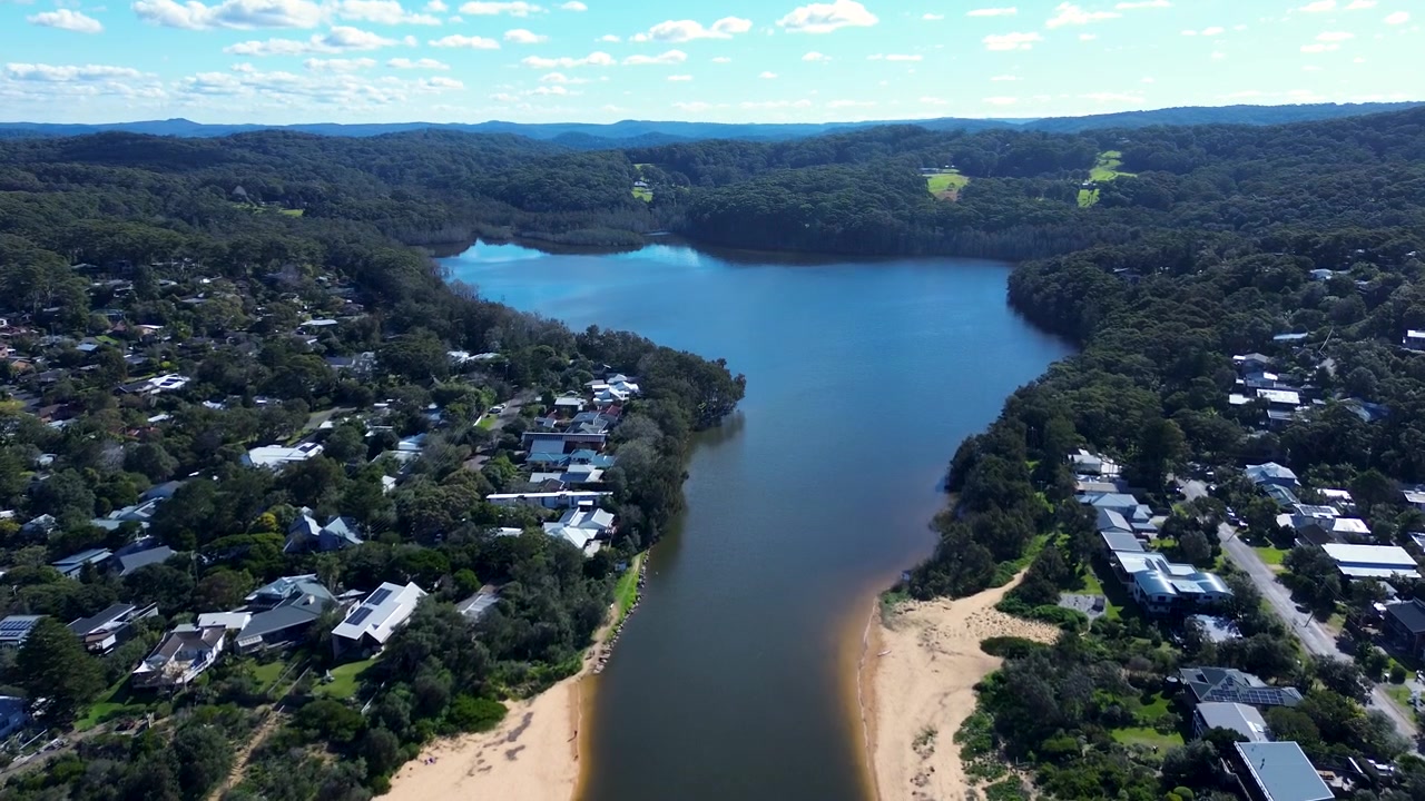 Paesaggio aereo con drone delle vie d'acqua della laguna di Cockrone, circondate da abitazioni residenziali suburbane e strade di quartiere, vicino a Copacabana e MacMasters Beach, sulla Central Coast, NSW, Australia, una destinazione turistica