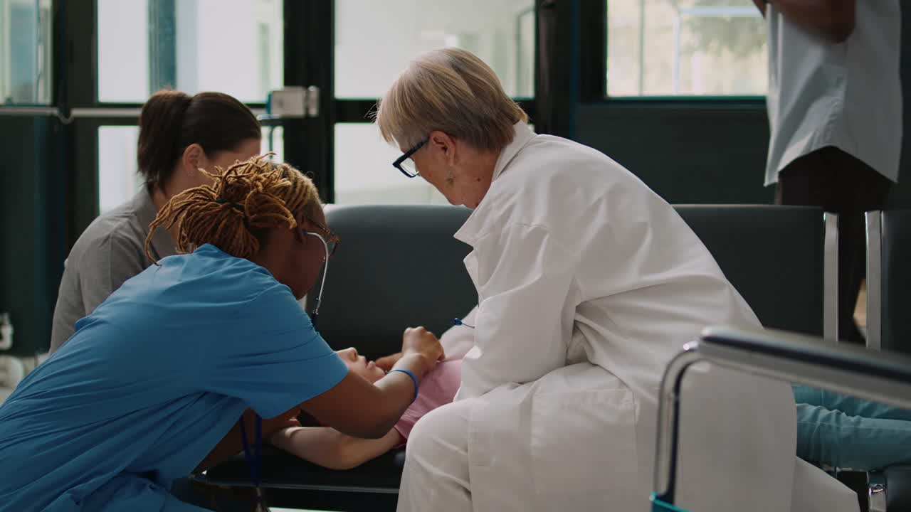 Little girl fainting in waiting area lobby and medic using flashlight