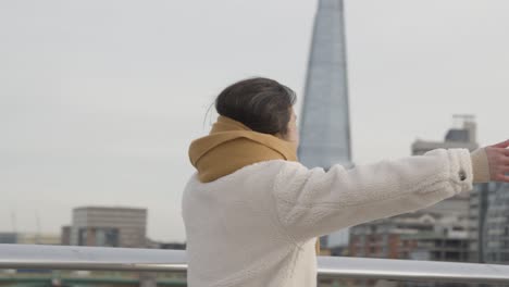 Young-Asian-Couple-Meeting-And-Hugging-On-Millennium-Bridge-In-London-UK-1