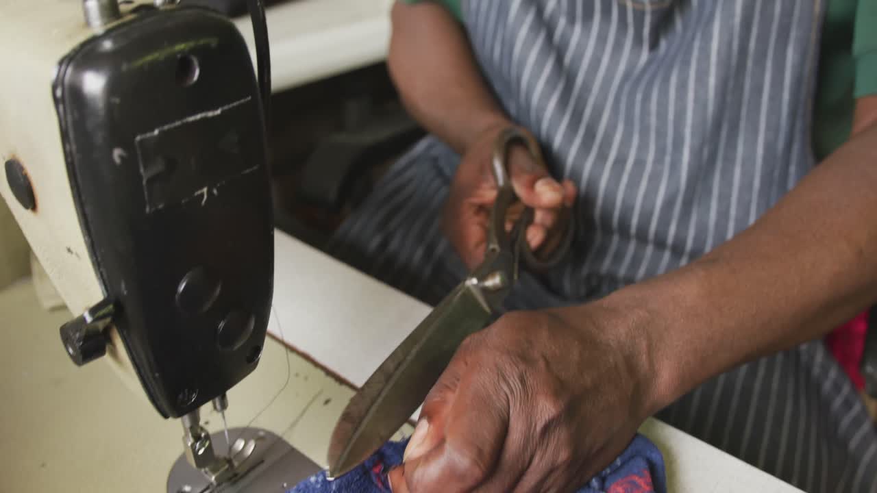hombre africano cosiendo tejido
