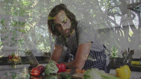 preparing vegetables in kitchen, man with animation of tree branches overlay
