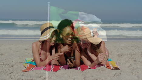 on beach, women in sun hats looking at smartphone with flag animation overlay