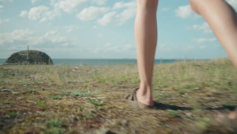 women walking in sandals towards the ocean, following handheld