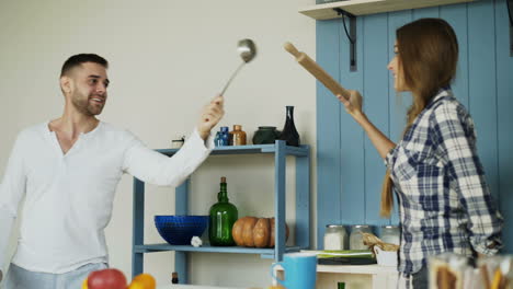 couple playing with kitchen utensils