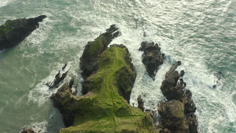 Vista-Aérea-De-Arriba-Hacia-Abajo,-Las-Olas-Chocan-Contra-Las-Rocas-A-Lo-Largo-De-La-Costa-Irlandesa-En-Kerry