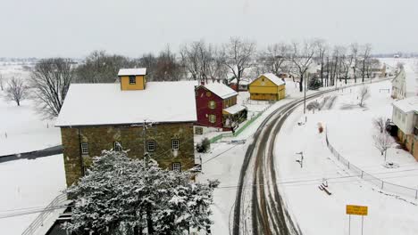 traditional mill and home, barn in lancaster county pa during winter snowstorm