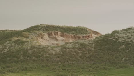 grassy sand dunes under a cloudy sky