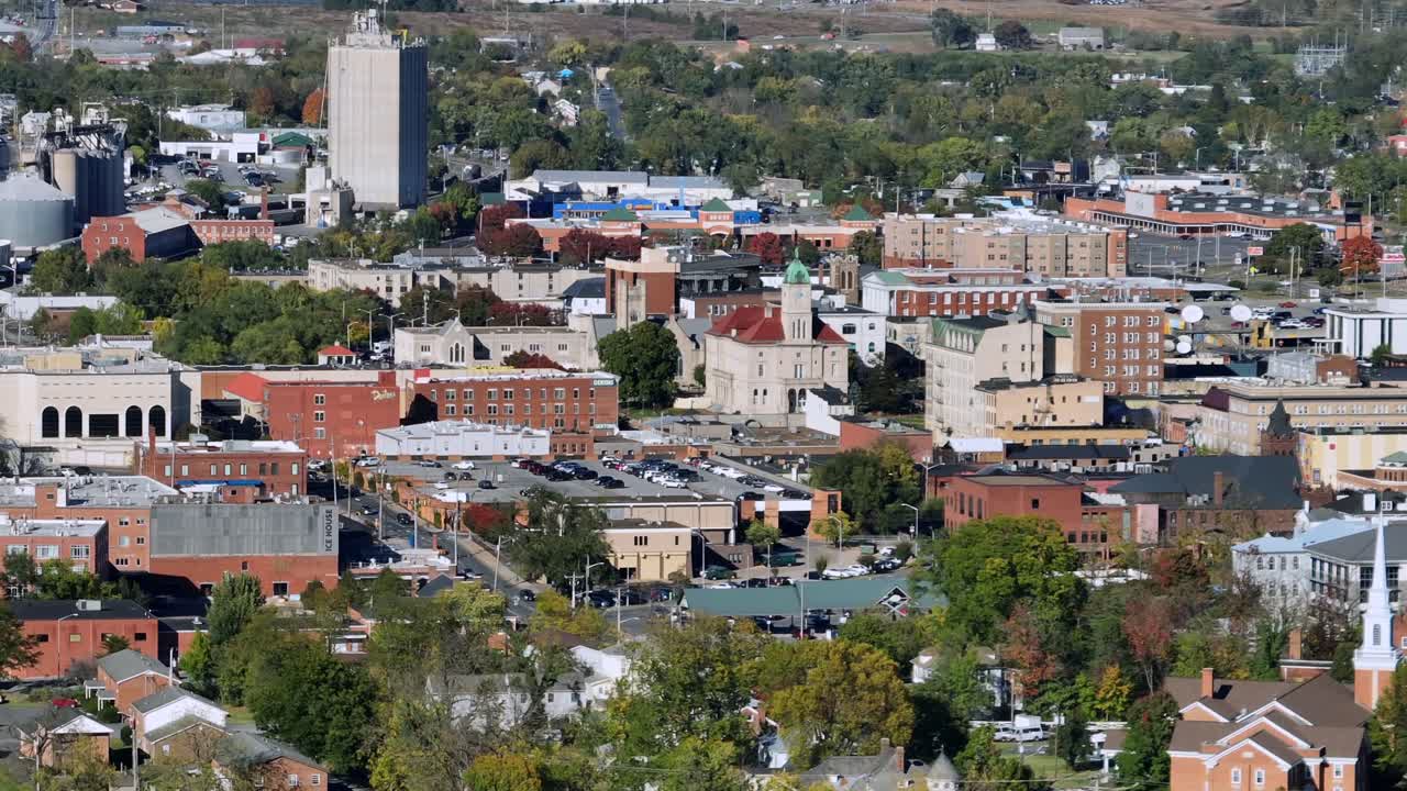 Panorama drone shot of Harrisonburg, Virginia on sunny day in fall season. Colored trees and downtown high-rise buildings of american town. Aerial wide shot
