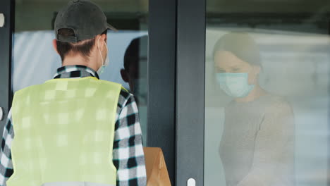 격리 기간 동안 주문한 음식을 집으로 받는 여성