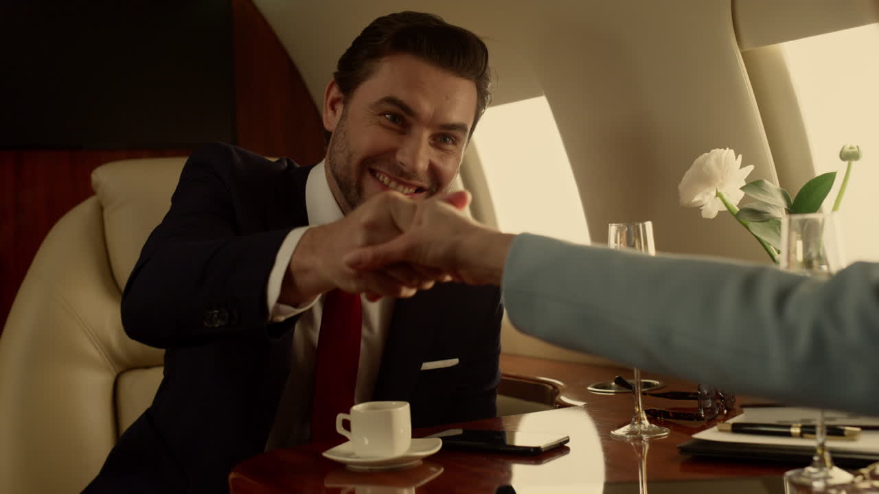 Primo piano di un uomo d'affari fiducioso che celebra un affare su un jet privato alla luce del sole.